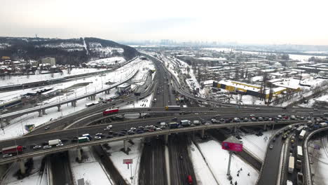 Car-traffic-on-highway-junction-in-winter-city.-Aerial-view-winter-crossroad