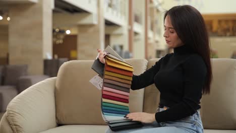 a woman in a store chooses the color of fabric for bed linen a woman in a store chooses the color of fabric for bed linen