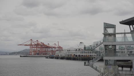 Vista-Del-Icónico-Edificio-Canada-Place,-Puerto-De-Vancouver-Y-Grúas-Rojas-En-Un-Día-Nublado,-Columbia-Británica,-Canadá