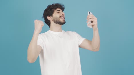 Young-man-using-smartphone-rejoices,-celebrates-victory,-wins.