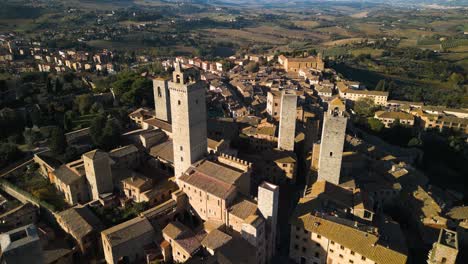 Drone-Flying-Away-from-San-Gimignano,-Tuscany,-Italy
