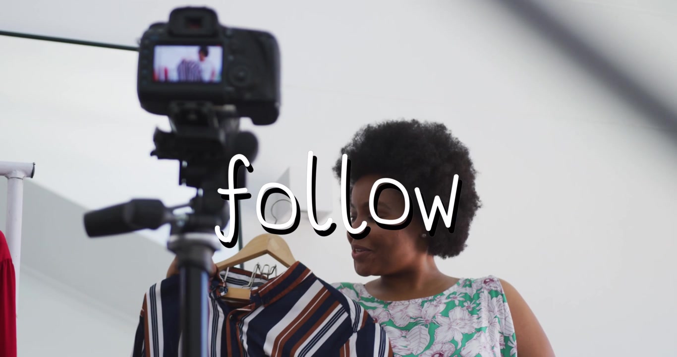 Animation of follow text over african american woman trying on clothes, making vlog using camera