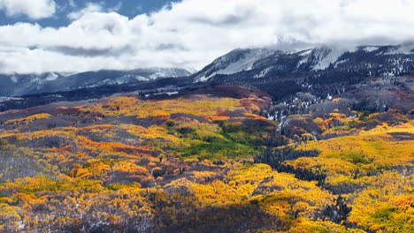 Kebler-Pass,-Filmische-Luftaufnahme,-Drohne,-Crested-Butte,-Gunnison,-Colorado,-Jahreszeiten-Kollidieren,-Frühherbst,-Espe,-Rot,-Gelb,-Orange,-Wald,-Winter,-Erster-Schnee,-Pulver,-Felsiger-Berggipfel,-Kreis,-Bewegung-Nach-Rechts