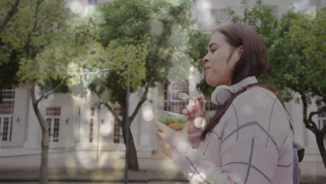 animación de puntos de luz sobre mujer caucásica comiendo almuerzo en la calle de la ciudad
