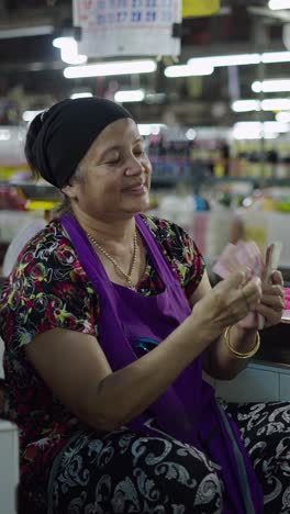 woman counting money in market