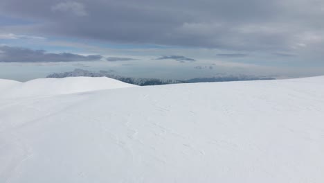 Weitläufige-Verschneite-Landschaft-Mit-Piatra-Craiului-Bergen-Im-Hintergrund,-Iezer-Papusa,-Arges