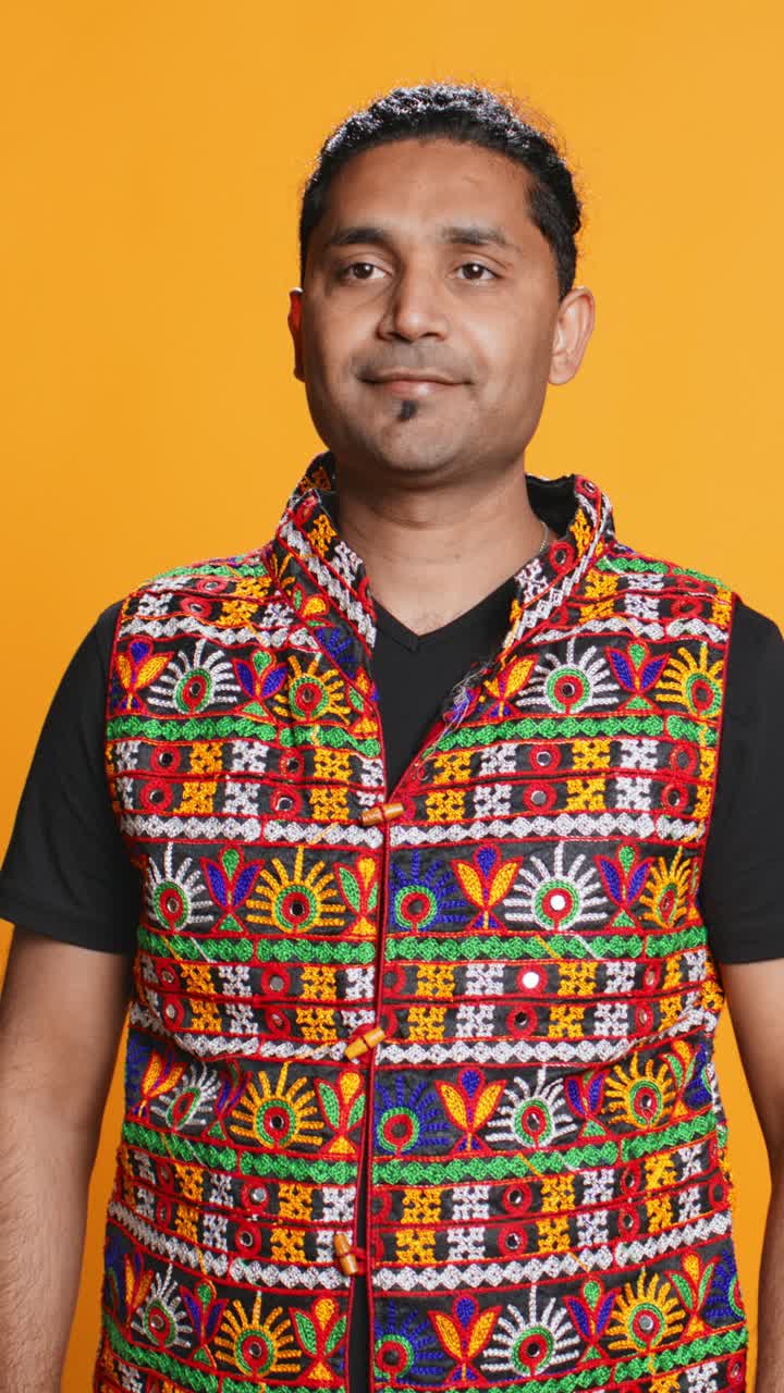 Retrato de estudio de un hombre con un chaleco tradicional bordado y colorido