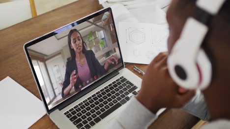 Estudiante-Universitario-Afroamericano-Sosteniendo-Notas-Mientras-Realiza-Una-Videollamada-En-Una-Computadora-Portátil-En-Casa