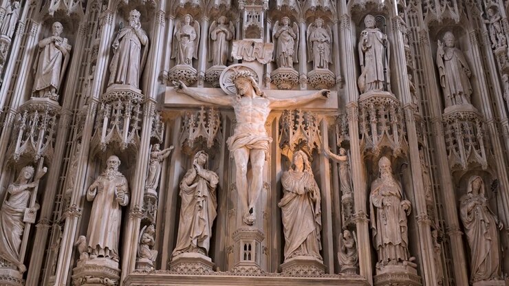 Gesù crocifisso e i santi circostanti scolpiti nella pala d'altare maggiore riempiono lentamente l'inquadratura in questa ripresa interna di una chiesa storica.