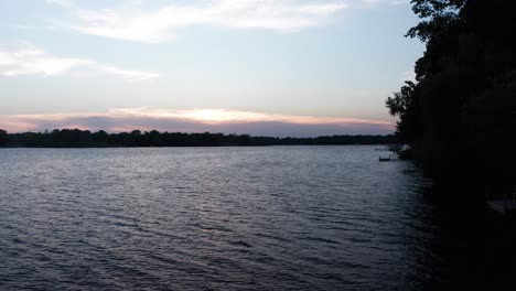 Low-aerial-descending-shot-over-cattails-blowing-in-the-gentle-breeze-on-a-lake-at-sunset