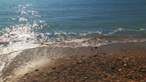 Ocean-waves-close-up-at-a-clear-bright-day,-tracking-left