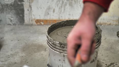 young male bricklayer builder kneads concrete, for laying aerated concrete blocks, using a construction mixer on a construction site.