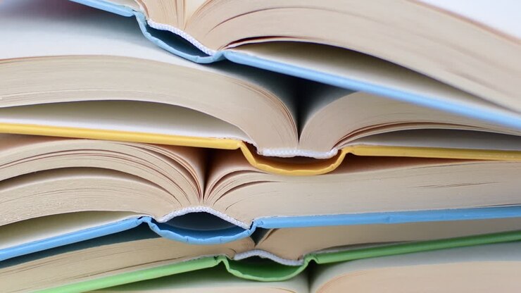 Scrivania con pila di libri di studio aperti. Libri di testo per studenti universitari. Studiare da casa. Concetto di didattica a distanza.