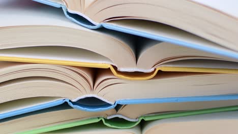 Desk with stack of open study books. Textbooks for the student, university. Study from home. Distance education concept.