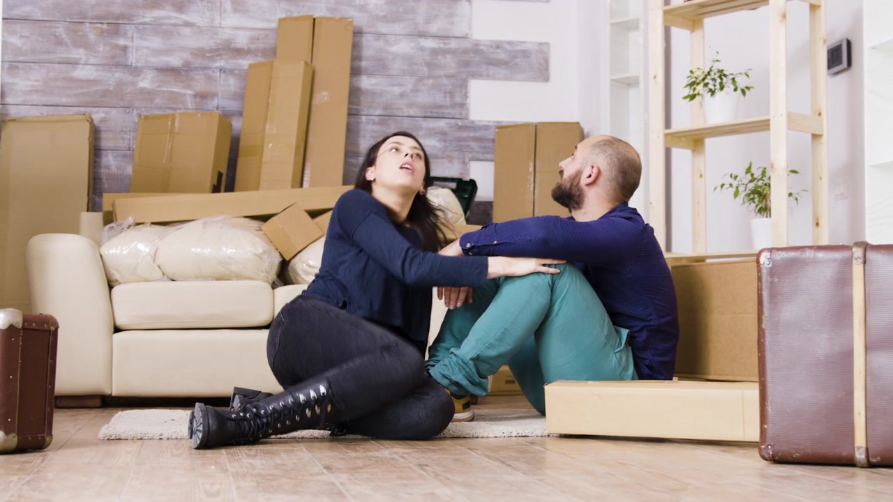 Exhausted Couple Resting on Floor After Moving Into New Home