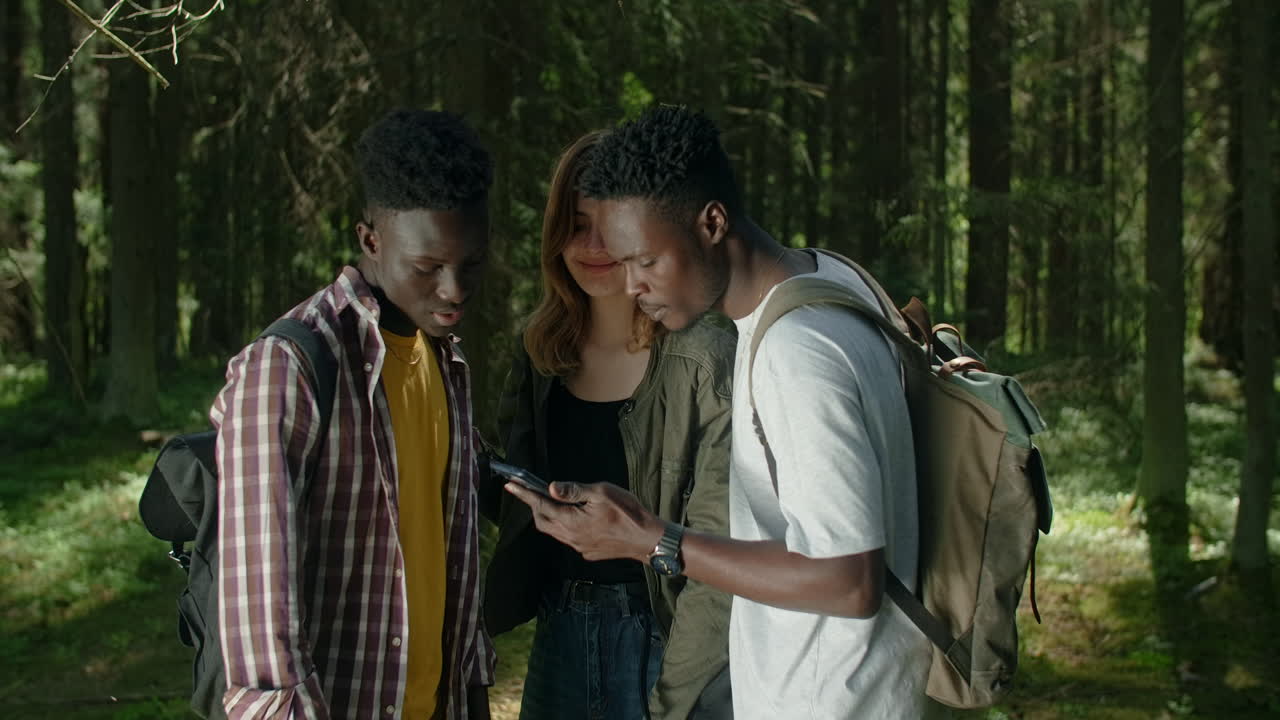 Friends using a smartphone in a forest