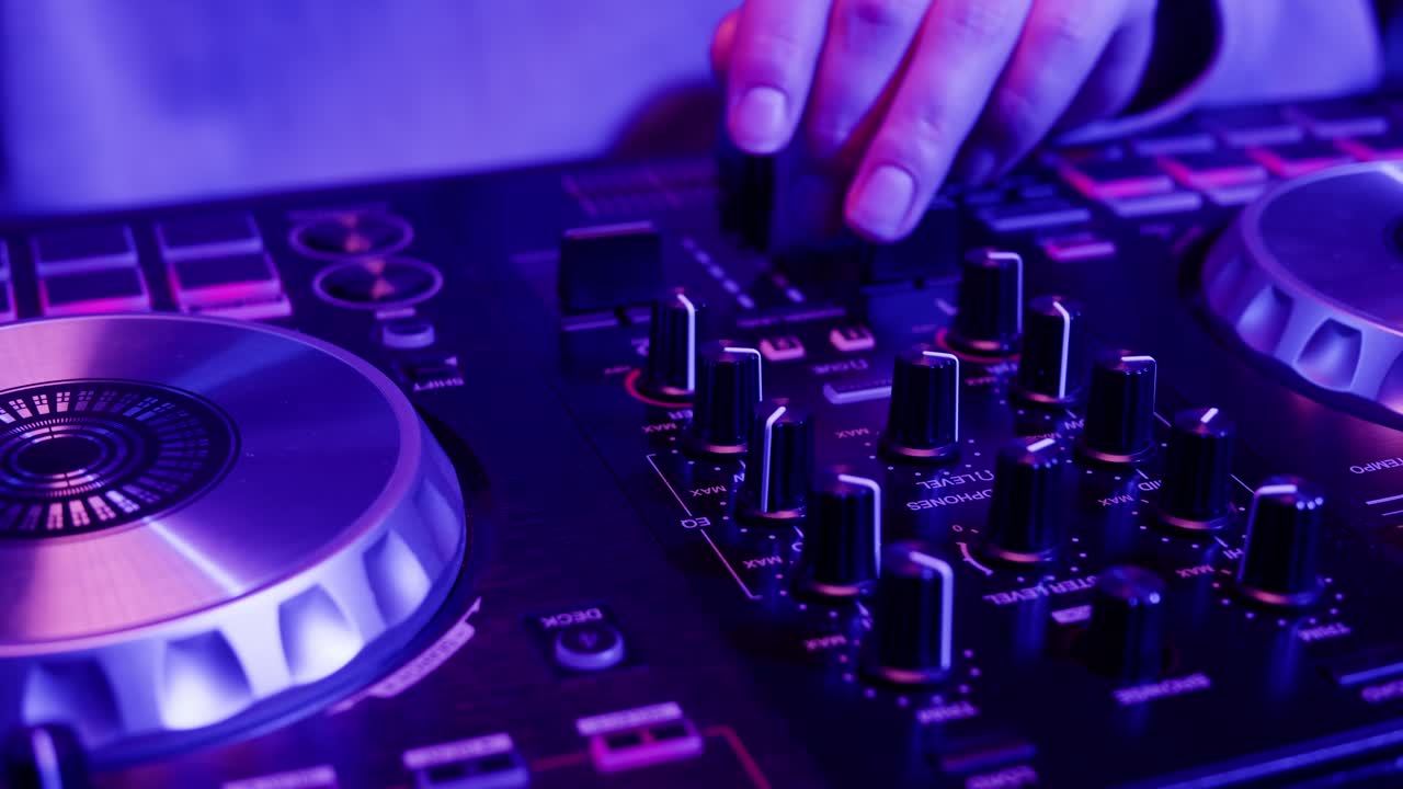 DJ with headphones and sunglasses playing music on festival in night club. Techno musician performing at nightclub for concert crowd of people, city bar.