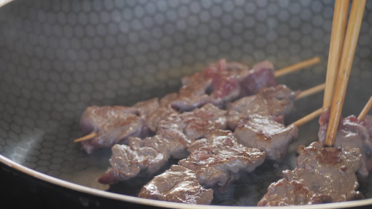 Pork meat skewer on fire, Mutton barbecue close-up. Fried meat for kebab. Cooking grilled meat beef chicken lamb BBQ . Kebab on grill. Chinese street local market with traditional food. Asian fast food.