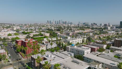 Dron-Sobre-El-Barrio-De-Los-ángeles-Durante-El-Día,-El-Horizonte-En-El-Horizonte-Y-Los-Tejados-De-Los-Apartamentos-Debajo