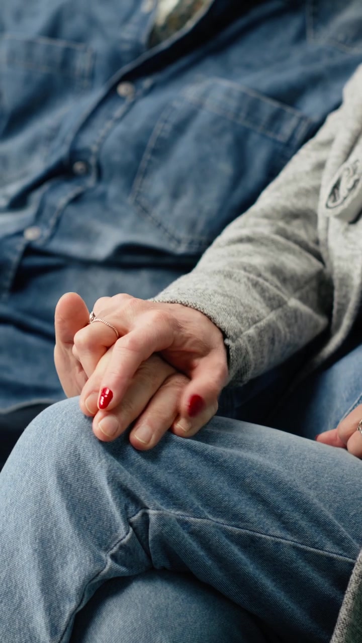 Vertical Video Close up of senior man and woman holding hands in airport lounge