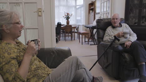 elderly couple relaxing at home with coffee