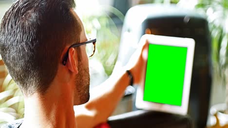 Man-using-digital-tablet-in-living-room