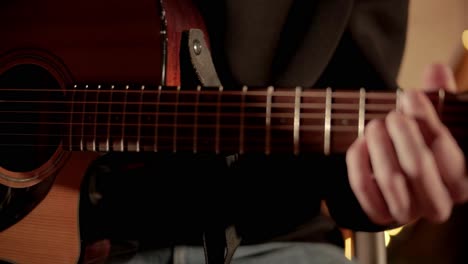 man plays the guitar and sings songs in a tent with light bulbs