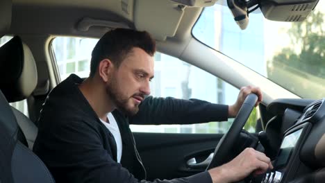 hombre elegante en un coche nuevo usar el sensor cerca del centro de negocios