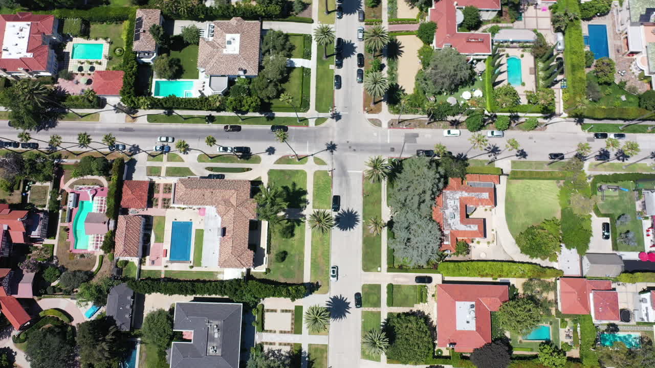 el dron se aleja para revelar calles bordeadas de palmeras con autos conduciendo y mansiones en west hollywood, california