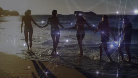 animación de redes de conexiones sobre un grupo feliz de amigos divirtiéndose, caminando por la playa