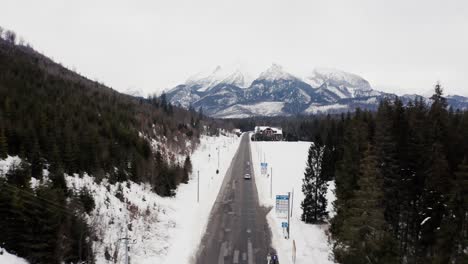 aerial view of an asphalt road with alpine mountains during winter in slovakia, central europe