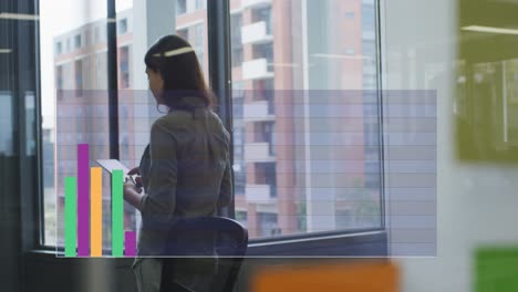 Animation-of-graphs-over-biracial-woman-walking-in-office