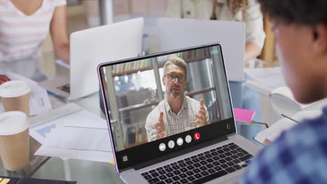 African-american-man-using-laptop-for-video-call,-with-business-colleague-on-screen