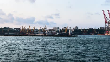 industrial harbour jib cranes at port of odesa from a boat sailing cruising at black sea