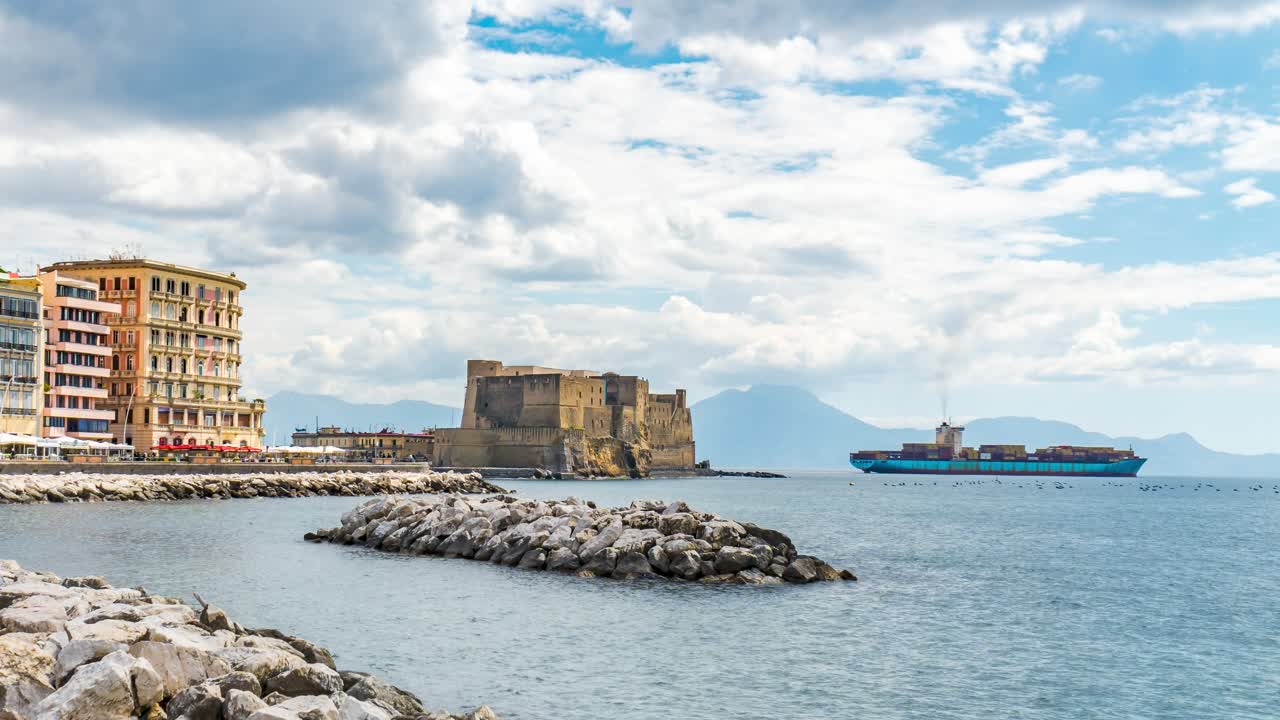 Ovo Castle, Naples Italy, wide view over bay with container ship in background partly cloudy day, time lapse