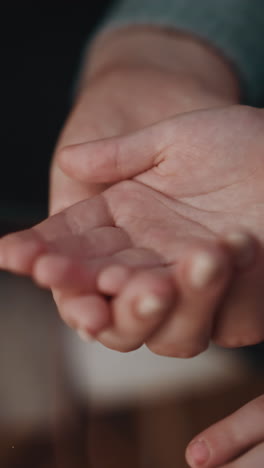 young woman puts small medicine on little daughter palm from glass pill bottle on blurred background in light room at home extreme close view slow motion