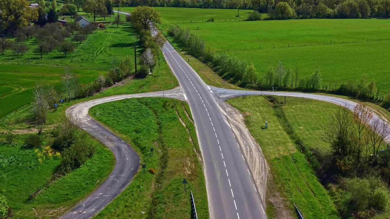 Svincolo a doppia carreggiata con rampa di collegamento nel dipartimento della Mayenne, regione Paesi della Loira, Francia, all'interno di un paesaggio agricolo a bocage, ripresa aerea con drone in planata in avanti