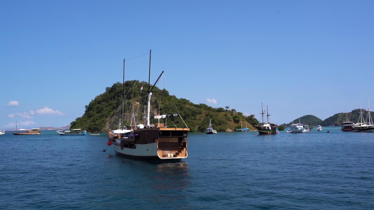 Traditional Boats Sailing Near The Island Under The Blue Sky In Bali, Indonesia. wide shot