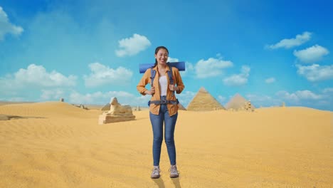 full body of asian female hiker with mountaineering backpack smiling to camera while traveling in pyramid of giza