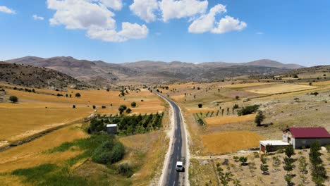 Fliegen-Der-Drohne-über-Die-Straße-Zwischen-Den-Hügeln,-Auf-Denen-Sich-Natürliche-Terrassen-Befinden