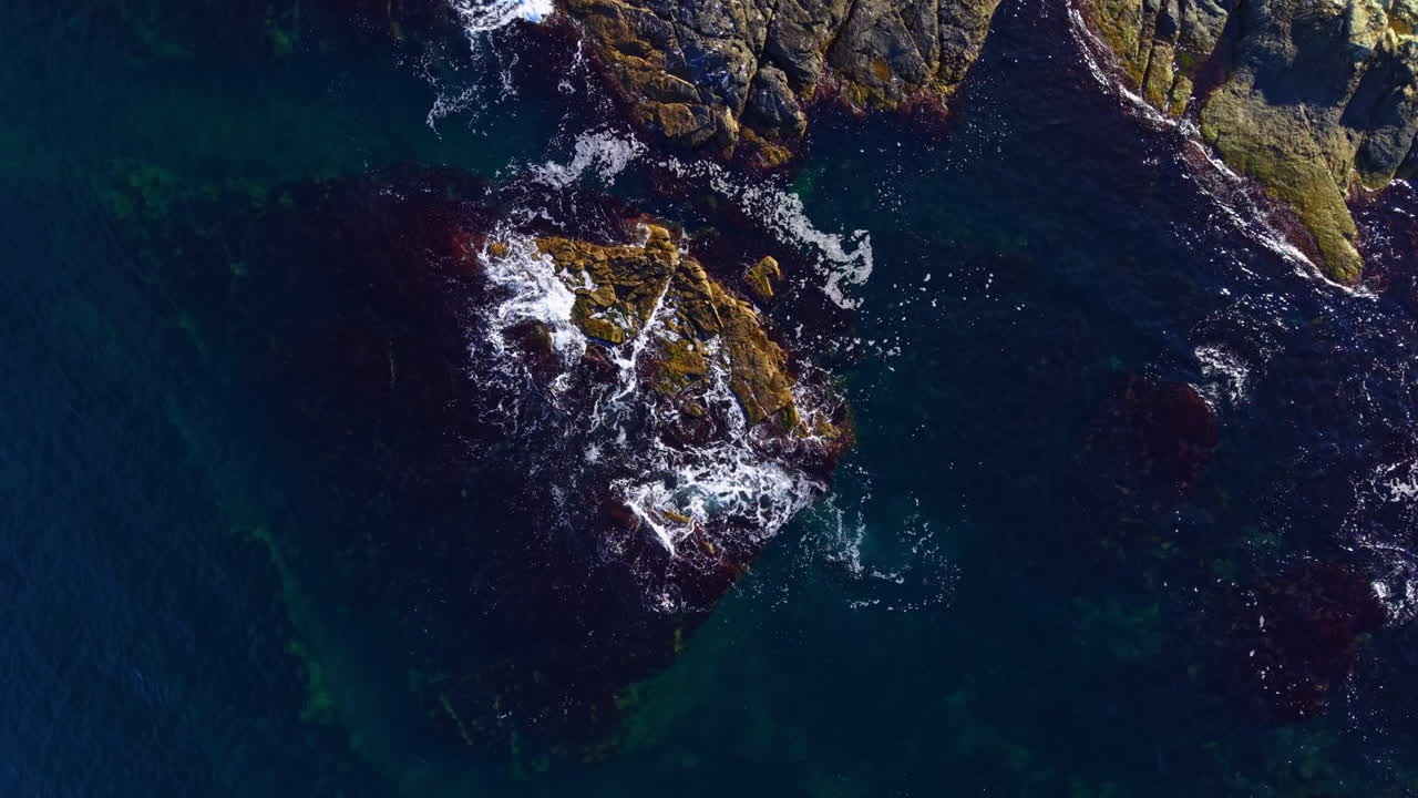 Waves gently crash against rocky shorelines, revealing the beauty of nature's dance at the ocean's edge