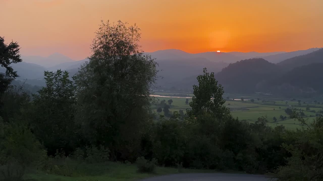 Layer landscape of rice paddy farm field and mountain sunset orange color background in forest climate country in Iran Gilan natural wonders of highland rural life hiking adventure couple camping Iran