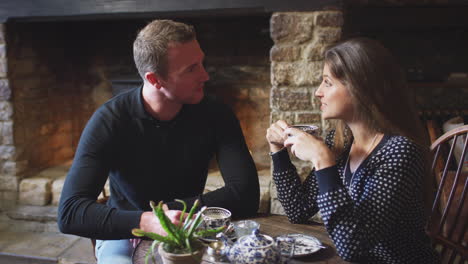 couple sitting at table drinking tea in traditional english holiday hotel