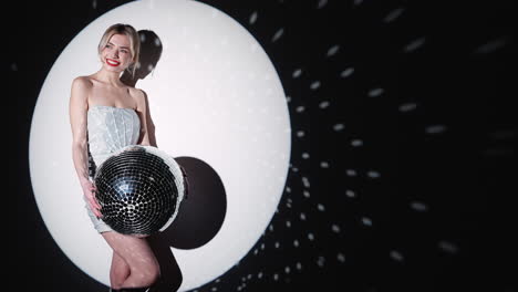 woman holding disco ball in spotlight