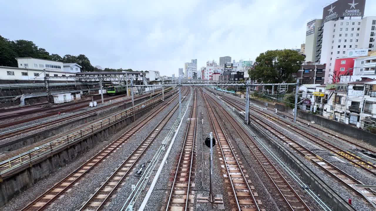 Train tracks stretch through Tokyo, with city buildings in the distance