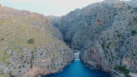 Stunning-4k-aerial-view-in-4k-of-the-famous-beach-Sa-Calobra-in-Mallorca,-Spain---Wide-view-Serra-de-Tramuntana---Massive-cliff-landscape-at-the-ocean---Mediterranean-Sea-Balearic-Islands