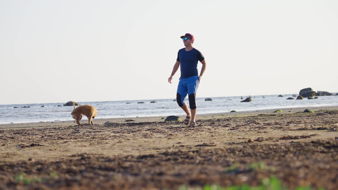 A man walks on the beach with his dog at Håverdal Nature Reserve, a peaceful moment.