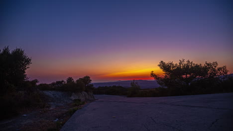 dramática puesta de sol roja proyectando su resplandor sobre un claro de bosque sereno - impresionante lapso de tiempo de una escena nocturna al aire libre