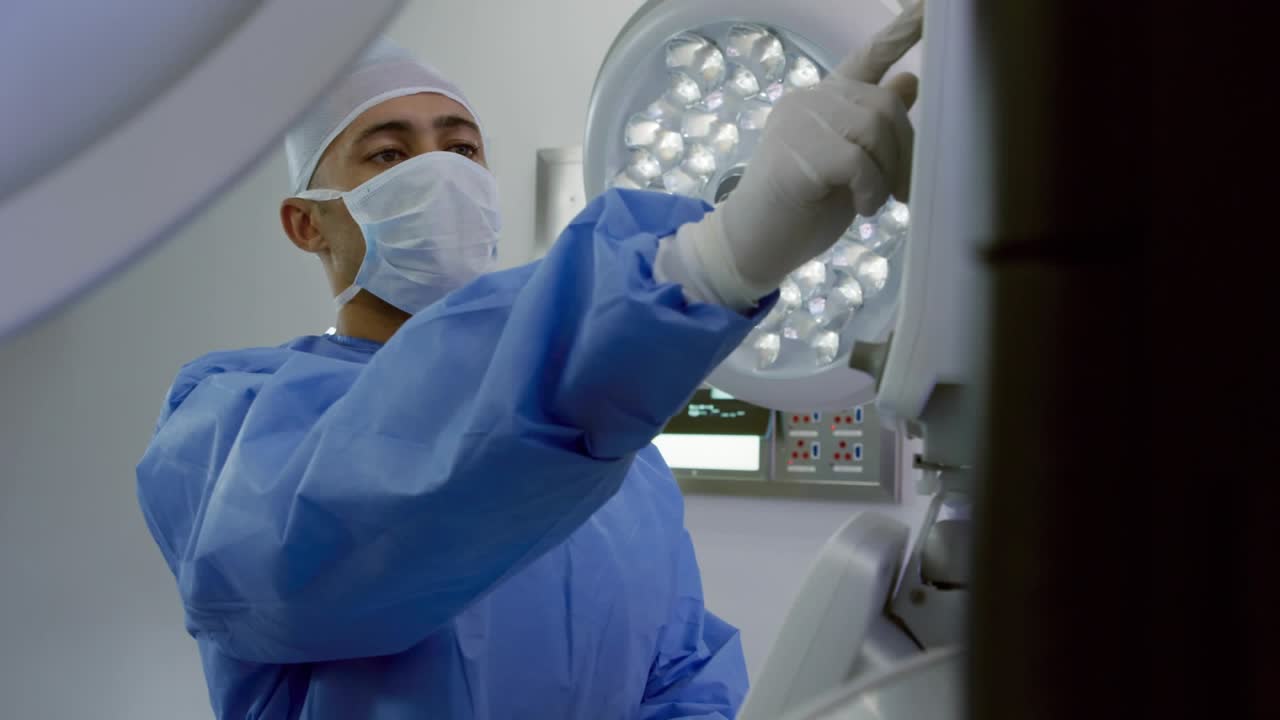 Surgeon tapping console button and rotating knob for lamp adjustment as heart overlays floating