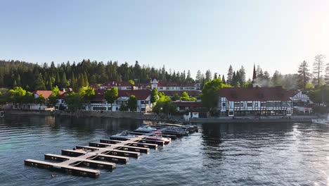 lake-arrowhead-village-california-during-sunset-with-chimney-smoke-and-a-pullback-over-the-boat-docks-showing-lots-of-speed-boats-and-pontoons-AERIAL-DOLLY-PULLBACK-RAISE-TILT